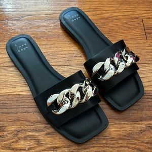 Size 7 black sandals with gold chain.